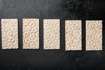 Grain diet light crisp bread , on black dark stone table background, top view flat lay, with copy...