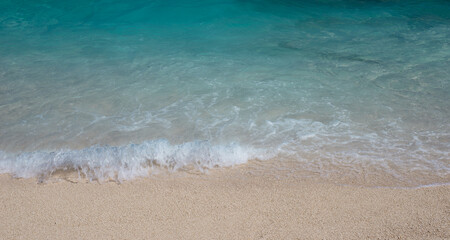 Fototapeta na wymiar Soft wave of the sea on the sand beach. Beach sand background.