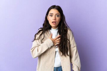 Young caucasian woman isolated on purple background surprised and shocked while looking right