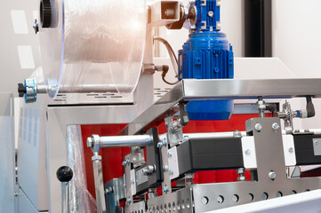 The operation of automatic plastic bag production machine with lighting effect. Close-up of the roller of the plastic bag production machine in the light blue scene. product packaging concept
