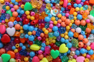 Fototapeta na wymiar Many different bright beads as background, top view