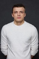 Fototapeta premium Portrait of a young man in the studio on a black background. Full face.