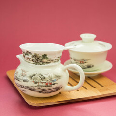 Gaivan and chahay with green tea  
 and tea brew on a pink background. Tea ceremony.  Traditional chinese tea utensils. 