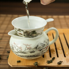 Gaivan and chahay with green tea  
 and tea brew on a brown background. Tea ceremony.  Traditional chinese tea utensils. 