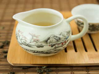 Gaivan and chahay with green tea  
 and tea brew on a brown background. Tea ceremony.  Traditional chinese tea utensils. 