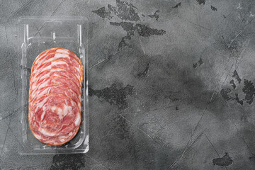 Dry smoked sausage pack, on gray stone table background, top view flat lay, with copy space for text
