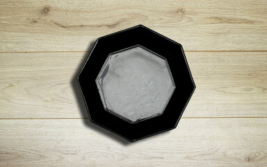 Empty ceramic black octagon polygon shape plate on wooden planks table