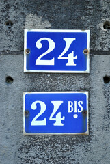 Close Up of Blue Enamel Numbers '24 and 24bis' on Building 