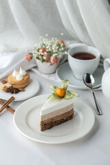 Slice of Triple Chocolate mousse Cake and cup of tea on the table