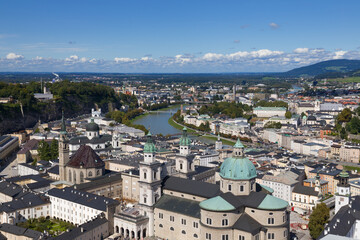 Fototapeta na wymiar Panorama from high angle view of urban scenery with famous Historic Centre (Altstadt) in Salzburg, Austria. Sunny day, blue sky, clouds. Austrian ancient historical monuments. Touristic destination.