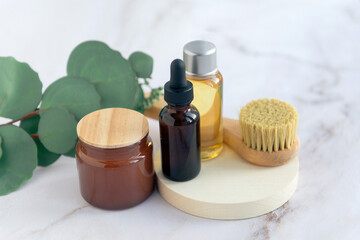 cosmetics products in bathroom - serum dropped bottle, face brush, candle and aroma oil