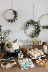 Beautiful cake and other treats on table in room. Baby shower party