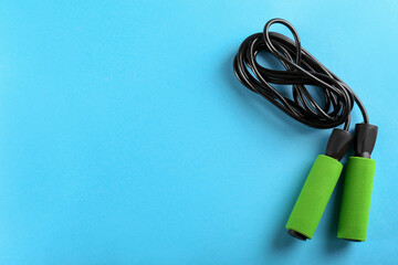 Skipping rope on light blue background, top view. Space for text