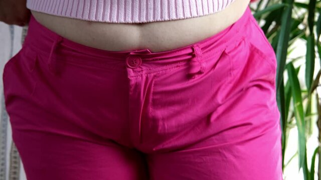fat woman in pink sweater measures waist circumference with centimeter tape, belly stands, concept time to lose weight, wrong lifestyle, consequences of inactivity, unhealthy diet