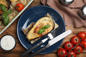 Delicious eggplant lasagna served on wooden table, flat lay