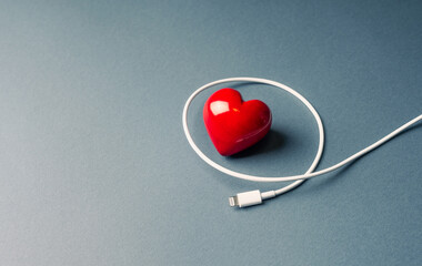 Life energy or Tiredness and its recharging concept with heart symbol and usb cable.