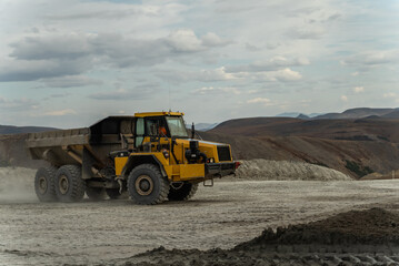 Articulated dump truck goes to the place of ore loading.