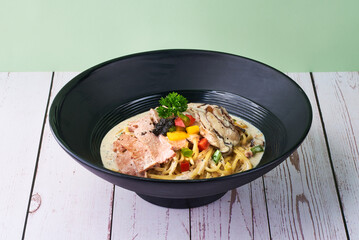 Italiano cuisine Pasta Truffle Cream in black bowl on wooden table