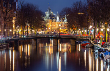 Obraz premium Beautiful old houses on the city waterfront of Amsterdam at sunset.