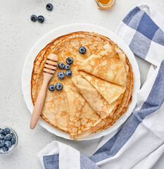 Crepes, thin pancakes or blini with berries in white plate. Top view. Pancake week. Shrovetide....