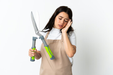 Young caucasian woman holding a plant isolated on white background with headache