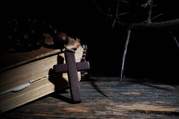 Rosary, ancient Bible and thorn wreath as symbol of death and resurrection of Jesus Christ.