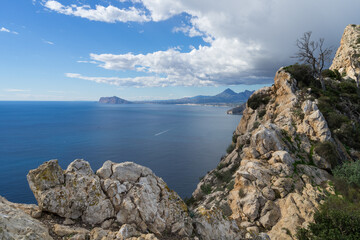 rocks and view of the blue mediterranean sea and mountains near the coast