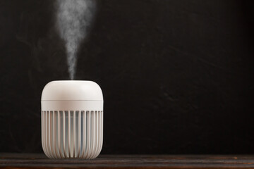 Modern air humidifier on black background