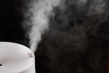 Modern air humidifier on black background