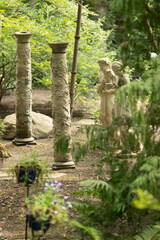 Obraz premium private garden with statues of women praying next to columns; meditation area
