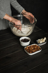 Baking sweet cottage cheese braided bread with raisins and jam. Mixing ingredients in a big bowl with a spoon. Lifestyle image.