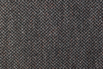 Gray wool fabric with zigzag stripes. Classic herringbone tweed, wool background texture. Coat close-up.