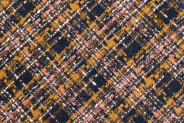 Red checkered fabric with colored threads. Scottish wool. Fabric for a plaid coat and suit. Close-up. Background