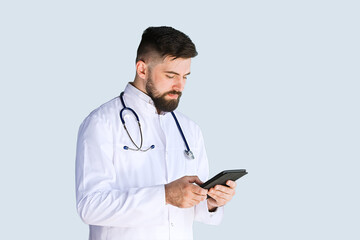 Healthcare, medicine concept: Handsome Doctor thinking about diagnosis on tablet computer isolated over grey color background