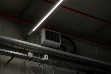 Hot water aerotherm fixed to the ceiling of a modern warehouse