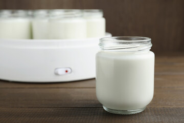 Obraz na płótnie Canvas Glass jar with tasty yogurt on wooden table. Space for text