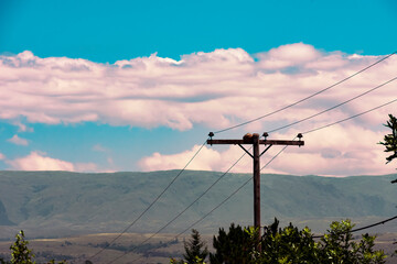 Panoramic view of an electric post crossing a country yard in the middle of the mountains