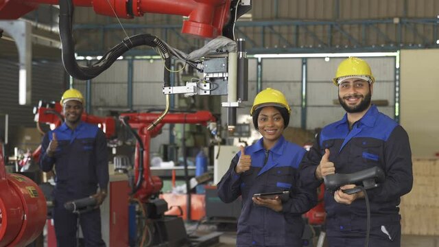 Team of Robotics engineer hand thumbs up happy smile for new project , automation robot in factory industrial for Production Line using system software support.