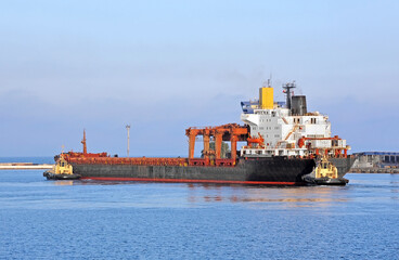 Tugboat assisting general cargo ship