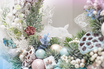 Christmas wreath in blue with a toy deer. Christmas card with deer in white and blue. Christmas composition with different balls, gifts on other toys