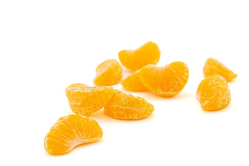 Peeled orange juicy Tangerine slices isolated on white background. Selective focus, blurred background