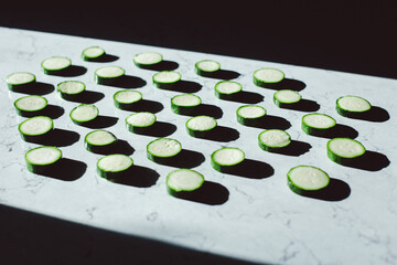 zucchini slices on a table with shadows