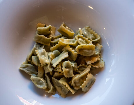 ravioli al plin with butter and sage in a white ceramic plate, in a restaurant in the Piedmontese Langhe