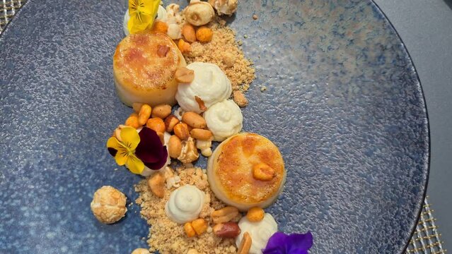 Lemon Creme Brule topped with cream, nuts, caramelized popcorn decorated with summer flowers. 4K