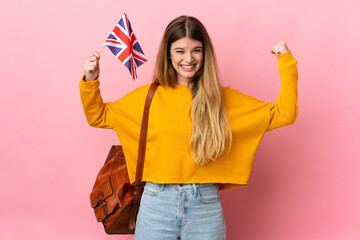 Young blonde woman holding an United Kingdom flag isolated on white background doing strong gesture - obrazy, fototapety, plakaty