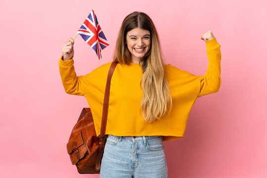 Young blonde woman holding an United Kingdom flag isolated on white background doing strong gesture