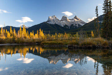 Sunset view in Canadian Rockies with Three Sisters peaks reflecting in water, Canmore, Alberta,...