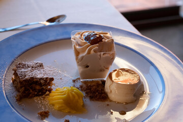 trio of desserts on a white ceramic plate served at a restaurant in the Piedmontese Langhe