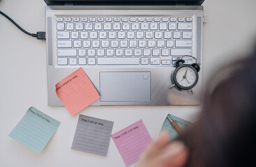 Laptop, notes and office stationery on a desk, top view. Overwhelmed with work, stress at work