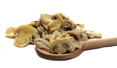 Champignon mushrooms slices with wooden spoon pile isolated on white  